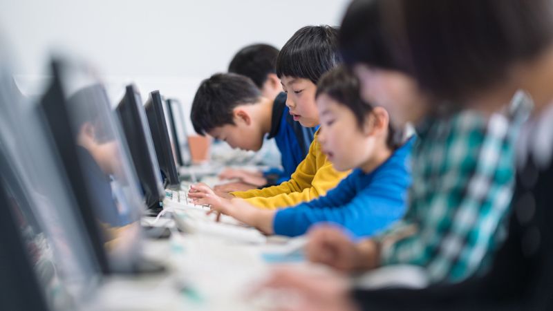 並んでキーボードをたたく子供たち